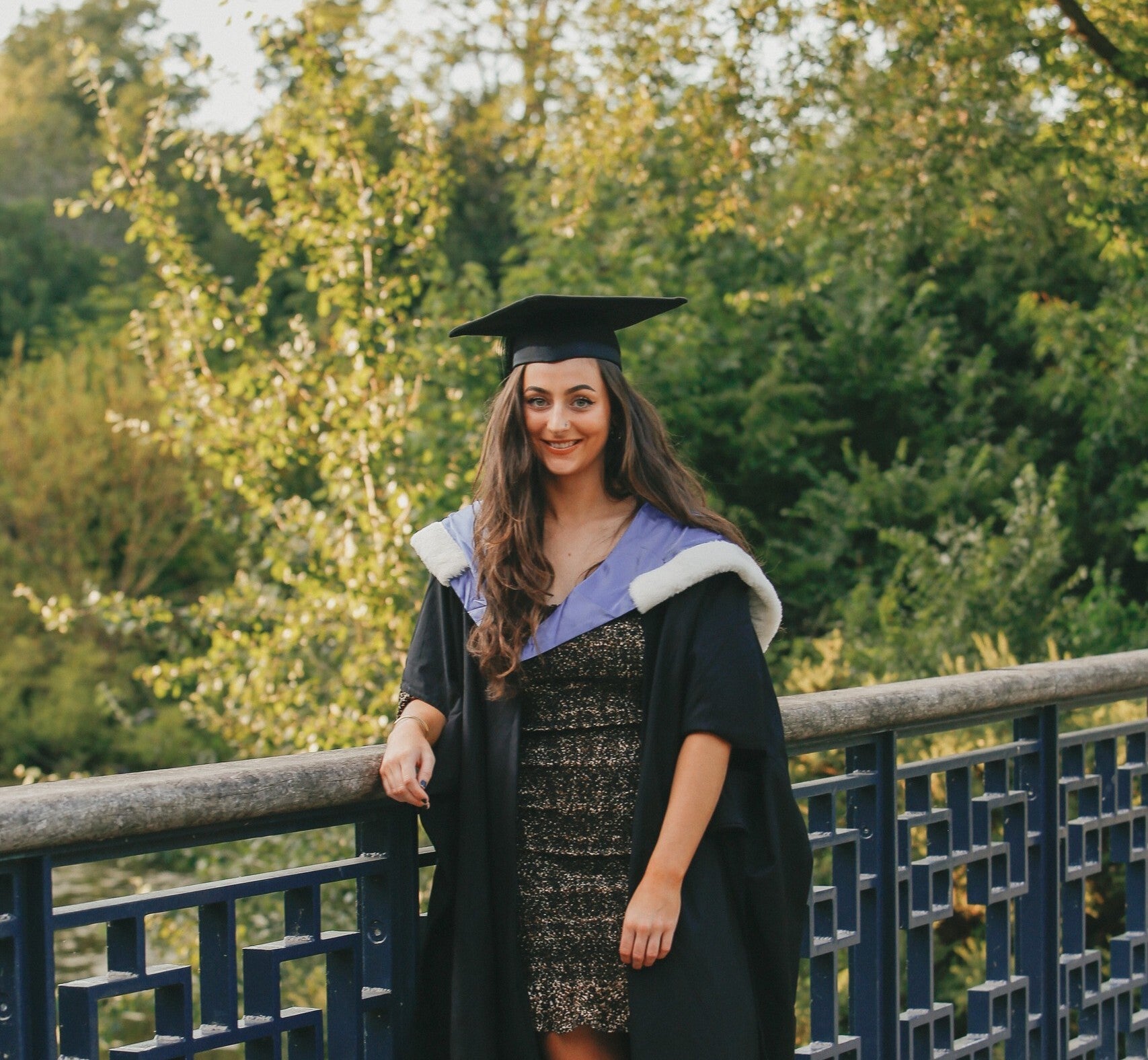 Graduate in gown and blue hood 